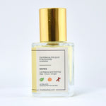 Perfume bottle with gold cap and white label on a light gray background
