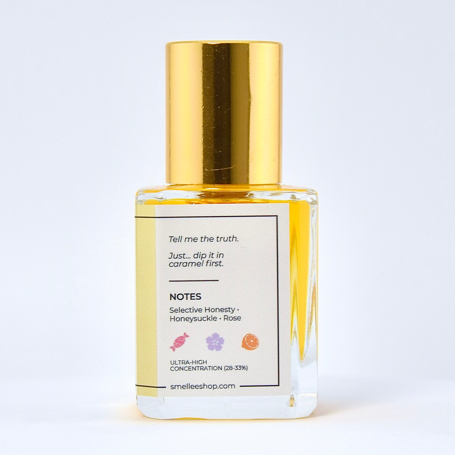 Perfume bottle with gold cap and white label on a light gray background